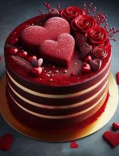 there is a red cake with hearts on the top and flowers in the bottom layer