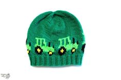 a green knitted hat with the word it's over written on it