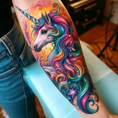 a woman's leg with an unicorn tattoo on the side of her arm and colorful swirls