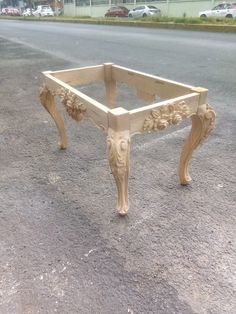 a wooden bench sitting on the side of a road