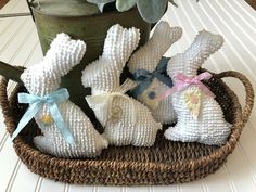 some white bunny figurines are sitting in a basket