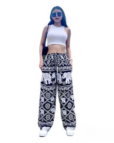 a woman with blue hair wearing an elephant print pants and cropped white tank top