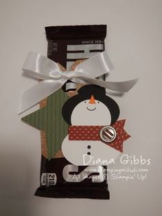 a bag of chocolate with a snowman on it's side and a ribbon tied around the top