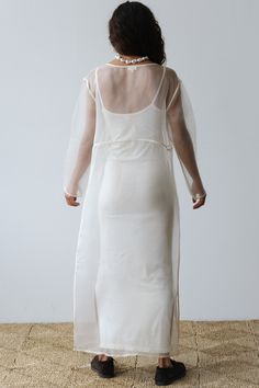 the back of a woman wearing a white dress