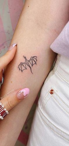 a woman with a bat tattoo on her arm