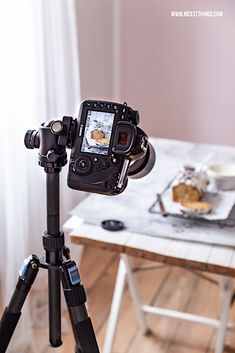 a tripod with a camera attached to it in front of a dining room table