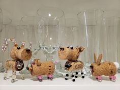 three wine glasses and some animal figurines on a shelf