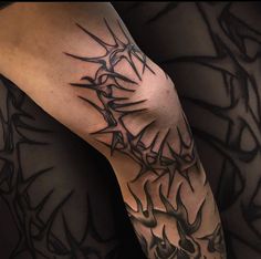 a man's arm with tattoos on it and his leg is covered in black ink