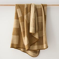 two folded towels hanging on a wall next to a towel rack and wooden hanger