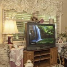 a living room filled with furniture and a flat screen tv sitting on top of a wooden entertainment center