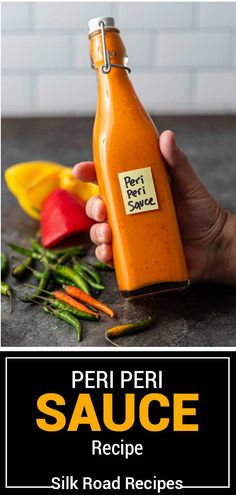 a person holding a bottle of hot sauce in front of some vegetables and peppers on the table