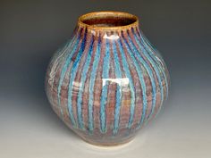 a blue and brown vase sitting on top of a table