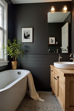 a bathroom with a tub, sink and large mirror on the wall next to it