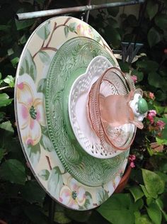 a green and white plate sitting on top of a wooden table next to some flowers