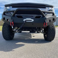 the front end of a black truck parked in a parking lot