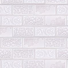 a white brick wall with decorative designs on it