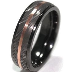 a black and rose gold wedding ring with an arrow inlay on the inside of it