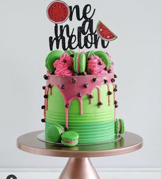 there is a cake that has been decorated with pink and green icing on it