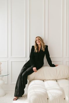 a woman sitting on top of a white couch