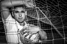 black and white photograph of a young man behind a soccer net