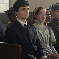 the young man and woman are sitting next to each other in front of an audience