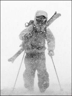 a man riding skis down a snow covered slope