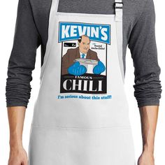 a man wearing an apron with the words kevin's famous chili on it