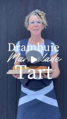 a woman holding a piece of bread with the words drambuie man made tart on it