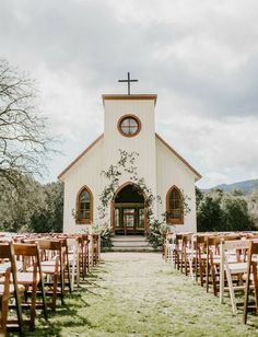 an outdoor wedding venue set up with wooden chairs