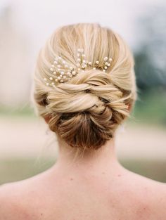 the back of a woman's head wearing a hair comb with pearls on it