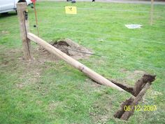 a wooden fence that has been dug into the ground