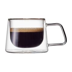 a glass mug filled with liquid sitting on top of a table