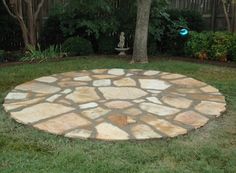 a circular stone patio in the middle of a yard