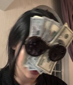 a woman with sunglasses and money in front of her face