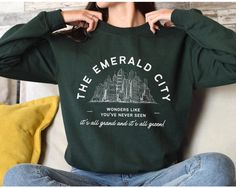 ❤ FACTS ❤ *This is a Unisex Gildan 18000 Crewneck Sweatshirt or Hoodie, Fits true to size. *PLEASE CHECK SIZING CHART BEFORE ORDERING :) *50% cotton, 50% polyester *Fabric weight: 8.0 oz/yd² (271 g/m²) *Pre-shrunk *1x1 athletic rib-knit collar with spandex *Air-jet spun yarn with a soft feel and reduced pilling ❤ CARE ❤ Machine wash INSIDE OUT: cold (max 30C or 90F); Do not bleach; Tumble dry: low heat; Do not iron the design; Do not dry clean. ❤ GOOD TO KNOW INFO ❤ *All orders are made to order just for you! *Shirt and design colors may slightly vary due to lighting and monitor settings *I love seeing photos of my items and smiles on your faces, please send photos to my Etsy messenger! *Leaving a review helps a small business continue to grow and puts a smile on everyone's faces 😀 ❤ SHIP Wicked Merch, Wicked Elphaba, Wicked Movie, City Sweatshirt, Hoodie Fits, Emerald City, Broadway Musicals