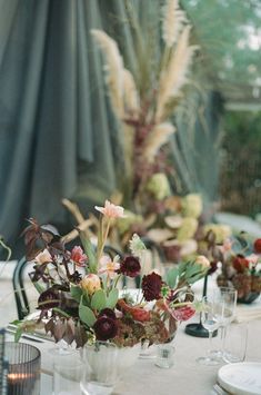 the table is set with flowers, candles and wine glasses for an elegant dinner party