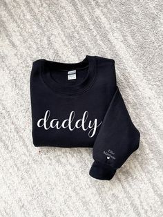 Our mama and daddy sweatshirts are personalized with the children's names on their wrist/sleeve making it a wonderful gift for Mother's Day, Father's Day, birthday, Christmas or just a special way to show off their love for their child(ren). These sweatshirts can be customized to change the name from mama and daddy to any special way the little ones call them!  ❤️       ** LISTING IS FOR ONLY ONE SWEATSHIRT -  CHECK OUT WITH 2 TO COMPLETE THE LOOK! **   ADULT SWEATERS ARE UNISEX  SMALL - 2XLARGE Black Cotton Hoodie For Gift, Black Cotton Hoodie As Gift, Family Matching Sweatshirt With Letter Print As Gift, Family Matching Sweatshirt With Letter Print, Family Matching Letter Print Sweatshirt As Gift, Customizable Long Sleeve Sweatshirt For Father's Day, Customizable Long Sleeve Family Matching Sweatshirt, Personalized Cotton Sweatshirt For Family, Personalized Cotton Family Sweatshirt