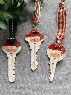 three christmas themed key ornaments hanging from a ribbon on top of a carpeted floor