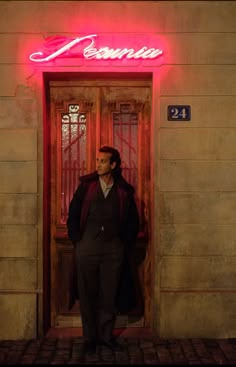 a man standing in front of a door with a neon sign above it that reads'ramon '