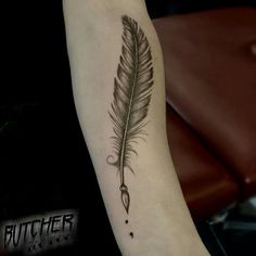 a black and white feather tattoo on the arm