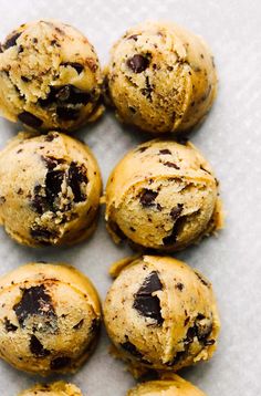 several chocolate chip cookies on a white surface