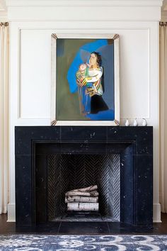 a living room with a fireplace and paintings on the wall