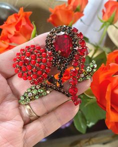 A stunning and Striking Large Vintage heart shaped brooch by Christian LaCroix, Paris. Christian LaCroix used the heart motif in so many pieces of his jewellery, but this one is exceptional.  The colour combination is alive and vibrant. The design is of two flower heads formed into the shape of a heart. Set with coral, ruby, black and peridot colour rhinestones. A large ruby tear drop rhinestone forms the centre of one flower heart. The open backed settings are in an antiqued rose gold colour fi Rose Gold Colour, Peridot Color, One Flower, Heart Motif, Antique Roses, Vintage Heart, Gold Colour, Colour Combination, Christian Lacroix