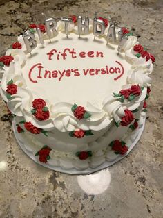 a white birthday cake with red roses on it and the words happy birthday written in frosting