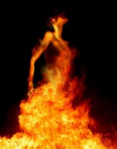 a woman standing on top of a pile of fire