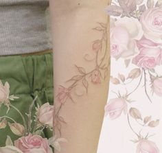 a woman's arm with pink roses on it and another tattoo design behind her