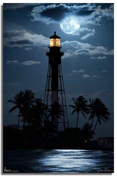 a light house sitting on top of a body of water under a moon filled sky