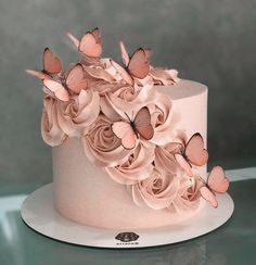 there is a pink cake with butterflies on it