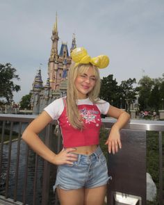 a young woman posing for a photo in front of a castle with her hands on her hips