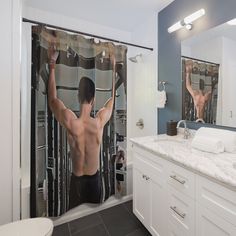 a man with his arms up in the air standing in front of a shower curtain